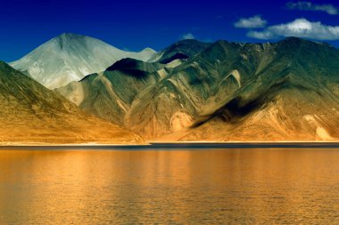 Arka planda mavi gökyüzü olan Pangong Tso Gölü 'ndeki dağların yansıması. Ladakh 'ta büyük bir göl olup Hindistan' dan Tibet 'e kadar 134 km uzunluğundadır. Leh, Ladakh, Jammu ve Kashmir, Hindistan