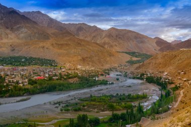 İndus nehri, Himalaya dağları ve arkada mavi bulutlu gökyüzü, Leh, Ladakh, Jammu ve Kashmir, Hindistan ile Kargil şehri etrafında döner.