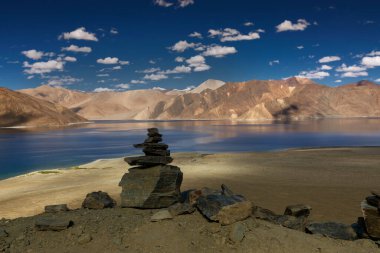 Pangong Tso (Göl) 'deki dağların mavi gökyüzü üzerindeki yansımaları ve kayaları. Ladakh 'ta büyük bir göl olup Hindistan' dan Tibet 'e kadar 134 km uzunluğundadır. Leh, Ladakh, Jammu ve Kashmir, Hindistan