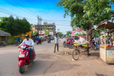 Cuttack, Odisha, Hindistan - 24 Temmuz 2019: Muz ve diğer sebzeler yol kenarında satılıyor. Bir adam scooterıyla marketin önünden geçiyor, Cuttack Bazar, Odisha 'da bir markette...