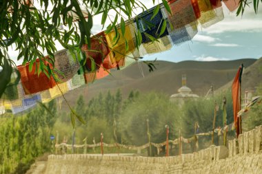 Buddhist religious flags, Play of light and shadow on mountains of Mulbekh, Himalayan mountains with shadow of clouds in background, Ladakh, Jammu and Kashmir, India clipart