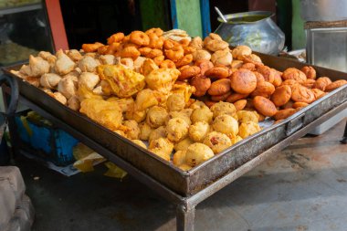 Piiyaji, Gulgula, bara, aloo chop, mangso chop gibi çeşitli fast food ürünleri, Thelawalla adlı tezgahtar tarafından satılıyor. Cuttack, Odisha, Hindistan 'ın sokak yiyecekleri..