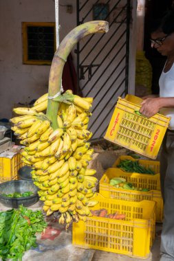 Cuttack, Odisha, Hindistan - 24 Temmuz 2019: Muz ve diğer sebzeler yol kenarında satılıyor. Genç adam bunları Cuttack Bazar, Odisha 'daki bir markette müşterilere satıyor..