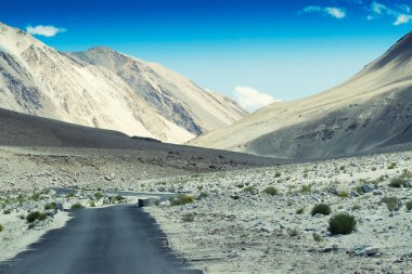 Güzel kayalık dağlara doğru beton bir yol Himalaya, Leh, Ladakh, Jammu ve Kashmir tepeleri olan mavi gökyüzü, Hindistan