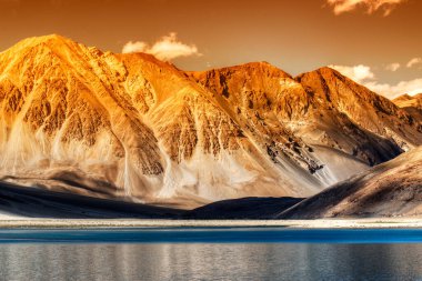 Güneşin batışında Güzel Dağlar ve Pangong (Göl). Ladakh 'ta Hindistan' dan Tibet 'e kadar uzanan büyük bir göl. Leh, Ladakh, Jammu ve Kashmir, Hindistan. Arka planda Himalaya dağları var. Renkli resim.