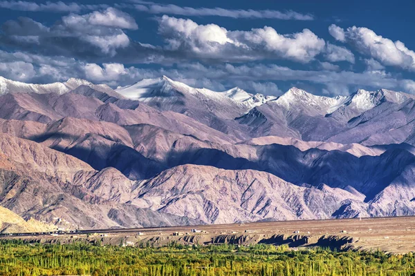 Arka planda buz zirveleri, bulutlu mavi gökyüzü, Ladakh, Jammu ve Kashmir 'in Rocky manzarası, Hindistan