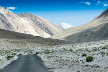 Güzel kayalık dağlara doğru beton bir yol Himalaya, Leh, Ladakh, Jammu ve Kashmir tepeleri olan mavi gökyüzü, Hindistan