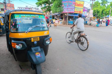 Cuttack, Odisha, Hindistan - 24 Temmuz 2019: Cuttack yolu manzarası, bisiklet süren bir kişi ve bir otorickshaw yol kenarında park edilir.