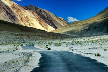 Güzel kayalık dağlara doğru beton bir yol Himalaya, Leh, Ladakh, Jammu ve Kashmir tepeleri olan mavi gökyüzü, Hindistan