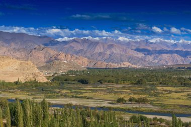 Arka planda buz zirveleri, bulutlu mavi gökyüzü, Ladakh, Jammu ve Kashmir 'in Rocky manzarası, Hindistan