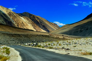 Güzel kayalık dağlara doğru beton bir yol Himalaya, Leh, Ladakh, Jammu ve Kashmir tepeleri olan mavi gökyüzü, Hindistan