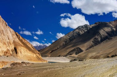 Ladakh 'ın Rocky dağları, mavi gökyüzü kabarık bulutlar, arka planda Himalaya dağları, Leh, Jammu ve Kashmir, Hindistan