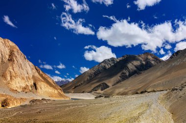 Ladakh 'ın Rocky dağları, mavi gökyüzü kabarık bulutlar, arka planda Himalaya dağları, Leh, Jammu ve Kashmir, Hindistan
