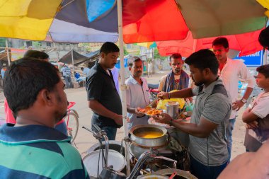 Cuttack, Odisha, Hindistan - 24 Temmuz 2019: Dahi Bara Alu Dum yol kenarında satıcılar tarafından sabah müşterilere satılıyor. Dahi baralar bir kaşık baharatlı aloo dum ile kaplanıp tabakta servis edilir..