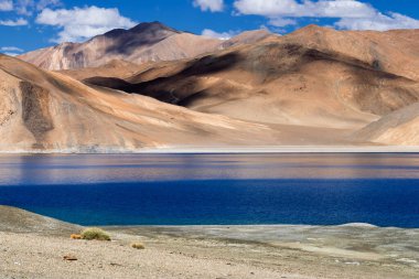 Pangong tso 'daki dağların yansıması (Göl) ve arka planda mavi gökyüzü. Ladakh 'ta büyük bir göl olup Hindistan' dan Tibet 'e kadar 134 km uzunluğundadır. Leh, Ladakh, Jammu ve Kashmir, Hindistan