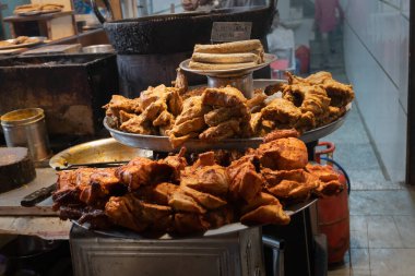Baharatlı tandır ezmeli tavuk, akşam satılmaya hazır Eski Delhi pazarında sokak yemeği olarak. Baharatlı Hint ve vejetaryen olmayan sokak yemekleri ile ünlüdür. Burası ünlü bir turistik yerdir..