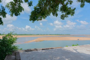 Odisha 'nın Mahanadi nehrinin güzel bir görüntüsü, mavi gökyüzü ve arka planda beyaz bulutlar. Yeşil yapraklar üstte. Kopya alanı ile Odisha 'nın doğa görüntüsü.