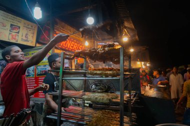 Old MARKET, NEW DELHI, INDIA - 28 Ekim 2018: Baharatlı tavuk kebapları erkekler tarafından hazırlanıyor ve yol kenarında sokak yemeği olarak satılıyor. Çeşitli sokak yemekleriyle ünlüdür..