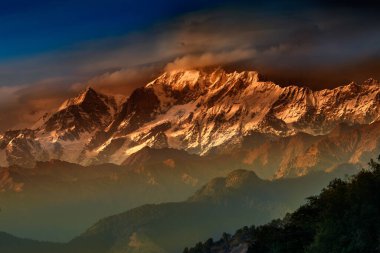 Garhwal Himalaya 'nın Gangotri Grubu' nda bir dağ kitlesi olan Chaukhamba 'da turuncu gün batımı. Uttarakhand, Hindistan 'daki Gangotri Buzulu' nun başındadır..
