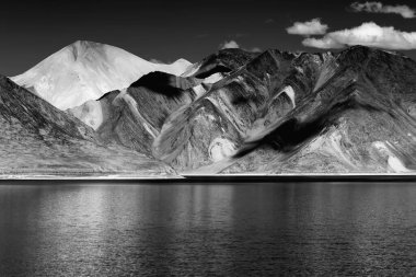 Pangong tso 'daki dağların yansıması Ladakh' ta 134 km uzunluğunda ve Hindistan 'dan Tibet' e kadar uzanan devasa bir göldür. Leh, Ladakh, Jammu ve Kashmir, Hindistan. Siyah ve beyaz resim.