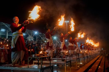 TRIBENI GHAT, RISHIKESH, UTTARAKHAND, INDIA - 29 Ekim 2018: Kıyılarda ünlü Ganga Aaarti, nehrin önünde el sallayan yüzlerce Hindu dindar tarafından Ganga Nehri için dua.