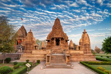 Khajuraho 'nun Doğu Tapınakları, Madhyapradesh, Hindistan' ın mavi gökyüzü ve arka planında kabarık bulutlar olan güzel bir görüntüsü, Hindistan 'daki dünyaca ünlü antik tapınaklar, UNESCO dünya mirası alanı..