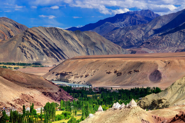Top view of ladakh landscape, green valley field with barren mountains around, play of light and shadow on mountains, Leh, Ladakh, India