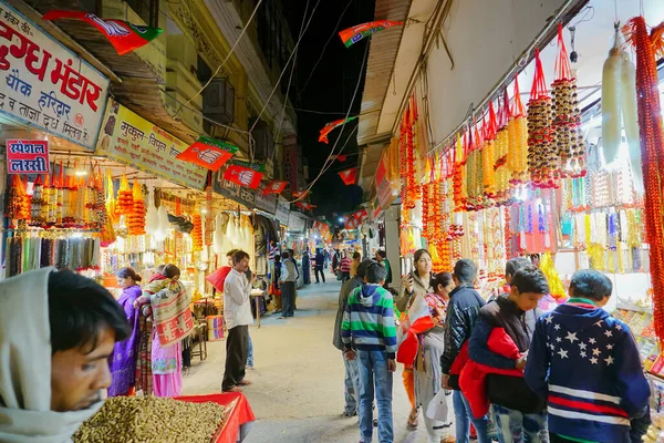 Haridwar, Garhwal, Hindistan - 3 Kasım 2018: Ticari mal satın alan turistler, Haridwar 'ı ziyaret eden turistler için ünlü bir pazar yeri olan Motibazar' ın gece görüntüsü.