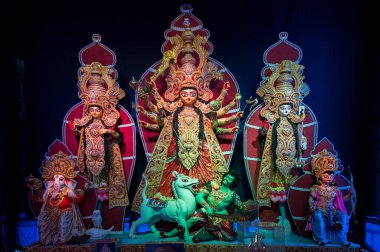 Durga Puja pandalını Tanrıça Durga aile idolü Durga Puja festivali ile süsledi. Howrah, West Bengal, Hindistan 'da renkli ışığın altında çekildi..
