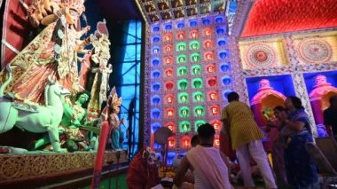 Howrah, Batı Bengal, Hindistan - 5 Ekim 2019: Durga Puja Festivali sırasında Durga Puja Pandalı 'nda Durga Tanrıçası Durga' ya tapan Bengalli kadınlar çiçek sunuyor, Bengalli kadınların italyan ayini.