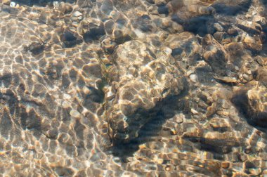 Güneş ışınları su altındaki taş ve kayalardan yansıyarak güzel soyut doğal desenler oluşturur. Görüntü: Reshi Nehri, Sikkim, Hindistan