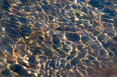 Güneş ışınları su altındaki taş ve kayalardan yansıyarak güzel soyut doğal desenler oluşturur. Görüntü: Reshi Nehri, Sikkim, Hindistan