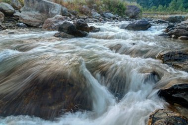 Şafakta taşların ve kayaların arasından akan güzel Reshi Nehri suyu, Sikkim, Hindistan. Reshi, Sikkim 'in en ünlü nehirlerinden biridir. Eyalette akar ve birçok yerel insana su verir.. 