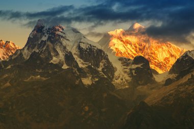 Kanchenjugha Dağı, Himalaya sıradağları, Sikkim, Hindistan 'da güneşin doğuşundan güzel bir gün ışığı. Şafak vakti dağlarda turuncu renkler