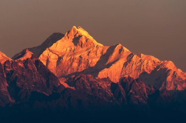 Kanchenjugha Dağı, Himalaya sıradağları, Sikkim, Hindistan 'da güneşin doğuşundan güzel bir gün ışığı. Şafak vakti dağlarda turuncu renkler.