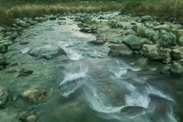 Beautiful Reshi River water flowing at dawn, Sikkim, India. Reshi is one of the most famous rivers of Sikkim flowing through the state and serving water to many local people. Greem tinted image.