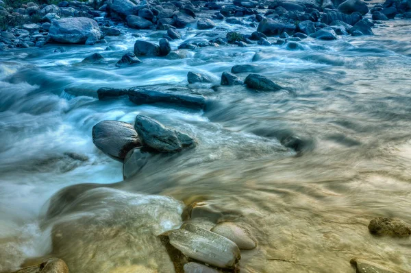 Beautiful Reshi River water flowing through stones and rocks at dawn,  Sikkim, India. Reshi is one of the most famous rivers of Sikkim flowing through the state and serving water to many local people.