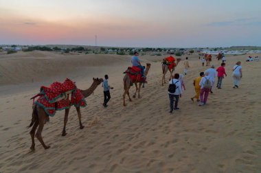Thar Çölü, Rajassthan, Hindistan - 15 Ekim 2019: Thar Çölü 'nün kum tepelerinde deveye binen turistler. Deve sürmek burayı ziyaret eden tüm turistler arasında favori bir etkinliktir.,