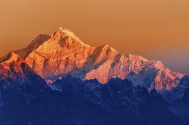 Kanchenjugha Dağı, Himalaya sıradağları, Sikkim, Hindistan 'da güneşin doğuşundan güzel bir gün ışığı. Şafak vakti dağlarda turuncu renkler