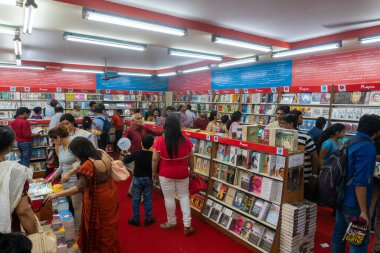 KOLKATA, INDIA - 9 Şubat 2018: Bengalli müşteriler kitap fuarında renkli bir kitapçıdan kitap almak için kitaplarını seçiyorlar. Dünya 'nın en büyük, en katılımcı ve en ünlü ticaret dışı kitap fuarıdır..