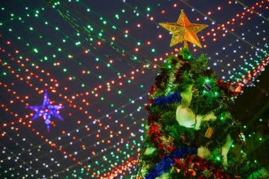 Büyük bir noel ağacı, geceleri Kolkata 'nın ünlü Anglo-Hindistan caddesi olan Bow Kışlası' nın ışıklarıyla aydınlanır. Tepemizde dekoratif ışıklar.