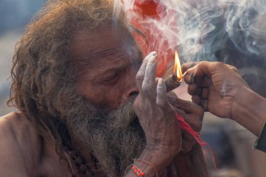 BABUGHAT, KOLKATA, Batı BENGAL / INDIA - 11 HAZİRAN 2015: Esrar içen Hindu Sadhu, yerel olarak Ganja, bir tür kanabis sativa .