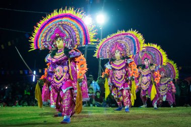 BAMNIA, PURULIA, WEST BENGAL , INDIA - DECEMBER 23RD 2015 : Four masked dancers performing at Chhau Dance festival, shot under colored lights. It is a very popular Indian tribal martial dance performed at night amongst spectators. clipart