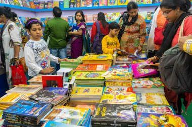 KOLKATA, INDIA - 9 Şubat 2018: Genç Bengalli kız kitaplarını Kolkata kitap fuarında renkli bir kitapçıda seçiyor. Dünya 'nın en büyük, en katılımcı ve en ünlü ticaret dışı kitap fuarıdır..