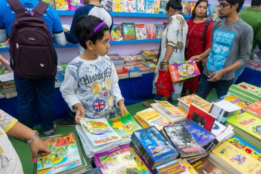 KOLKATA, INDIA - 9 Şubat 2018: Genç kız kitaplarını Kolkata kitap fuarında renkli bir kitapçıdan alıyor. Dünya 'nın en büyük, en katılımcı ve en ünlü ticaret dışı kitap fuarıdır..