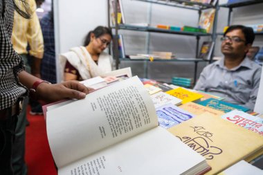 KOLKATA, INDIA - 9 Şubat 2018: Müşteriler Kolkata kitap fuarında renkli bir kitapçıdan kitap satın alıyorlar. Dünya 'nın en büyük, en katılımcı ve en ünlü ticaret dışı kitap fuarıdır..