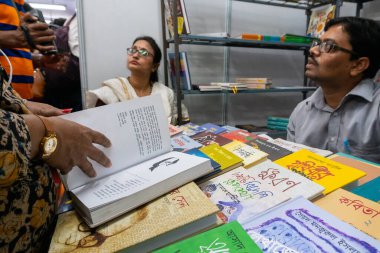 KOLKATA, INDIA - 9 Şubat 2018: Kolkata kitap fuarındaki güzel Bengalli kadın müşterilerin sorularını cevaplayan kitap satıcısı. Dünya 'nın en büyük, en katılımcı ve en ünlü ticaret dışı kitap fuarıdır..