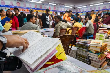 KOLKATA, INDIA - 11 Şubat 2018: Müşteriler Kolkata kitap fuarında renkli bir kitapçıdan kitap satın alıyorlar. Dünya 'nın en büyük, en katılımcı ve en ünlü ticaret dışı kitap fuarıdır..