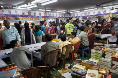 KOLKATA, INDIA - 11 Şubat 2018: Müşteriler Kolkata kitap fuarında renkli bir kitapçıdan kitap satın alıyorlar. Dünya 'nın en büyük, en katılımcı ve en ünlü ticaret dışı kitap fuarıdır..