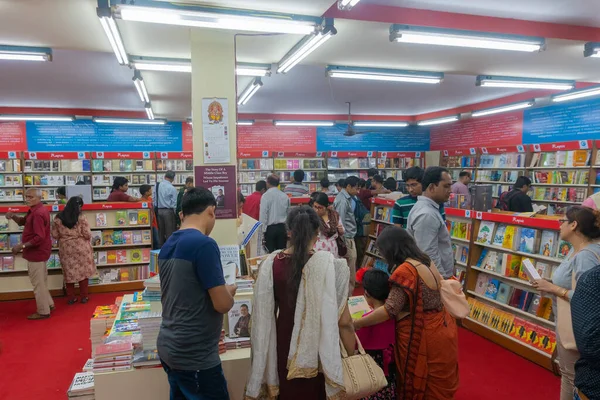 KOLKATA, INDIA - 9 Şubat 2018: Bengalli müşteriler kitap fuarında renkli bir kitapçıdan kitap almak için kitaplarını seçiyorlar. Dünya 'nın en büyük, en katılımcı ve en ünlü ticaret dışı kitap fuarıdır..